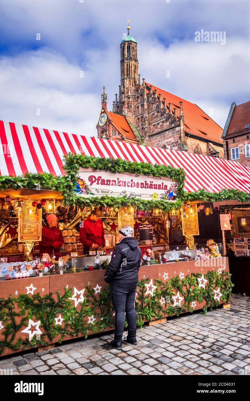 Nuremnerg, Germany - December 2018: People explore Christmas market on Nuremberg's Christkindlesmarkt one of Germany's oldest Christmas markets dating Stock Photo