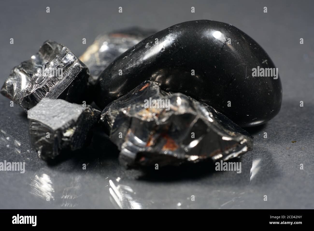 Selective focus shot of  raw shungite mineral on a smooth surface Stock Photo