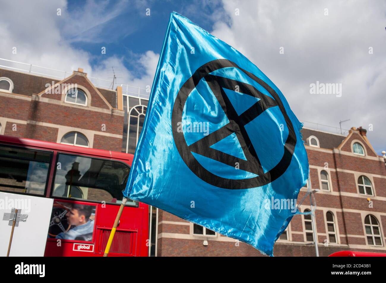 London, UK. 26th August 2020. Blue Extinction Rebellion flag flies outside Barclays Bank, Clapham Junction, South London. XR continue their ’Sharklays’ campaign, investigating Barclays Bank for crimes against humanity and the planet. XR state that Barclays is now the biggest European investor in fossil fuels. Credit: Neil Atkinson/Alamy Live News Stock Photo