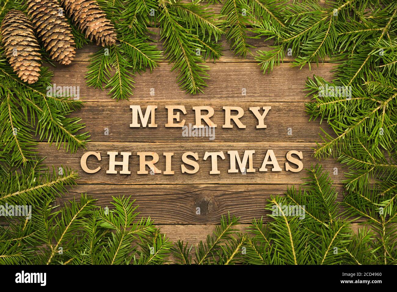 Inscription Merry Christmas on a wooden background. Frame made of fir ...