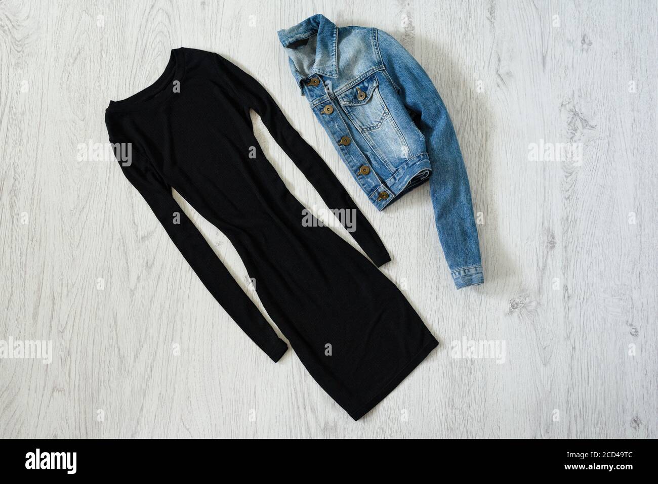 Little black dress and denim jacket on wooden background. Fashionable  concept Stock Photo - Alamy