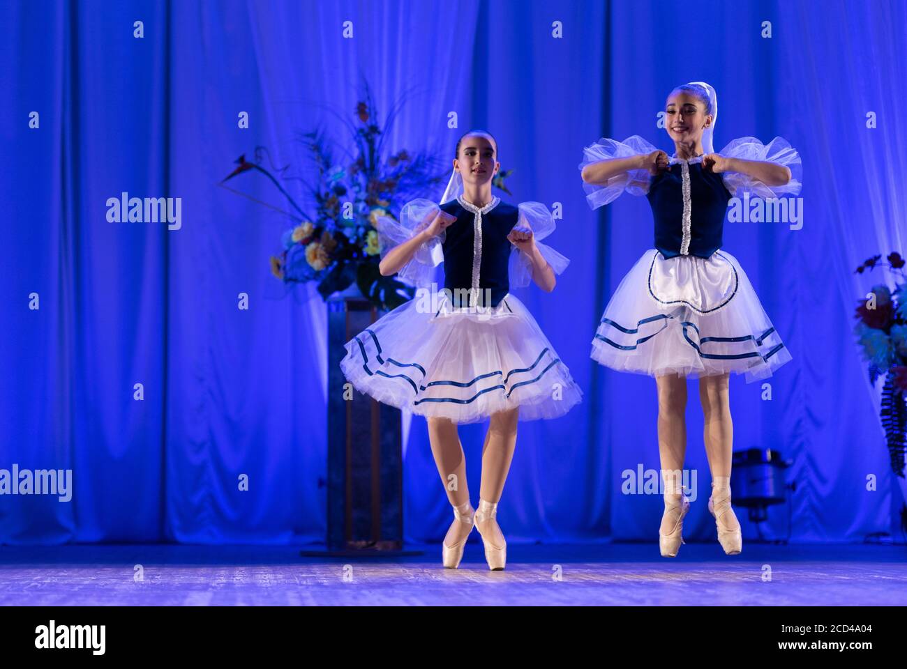 Young girls ballerina in a blue and white costume dancing ballet