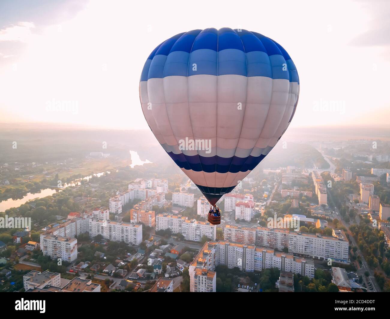 Colorful hot air balloon flying over small european city at summer sunset, Kiev region, Ukraine Stock Photo