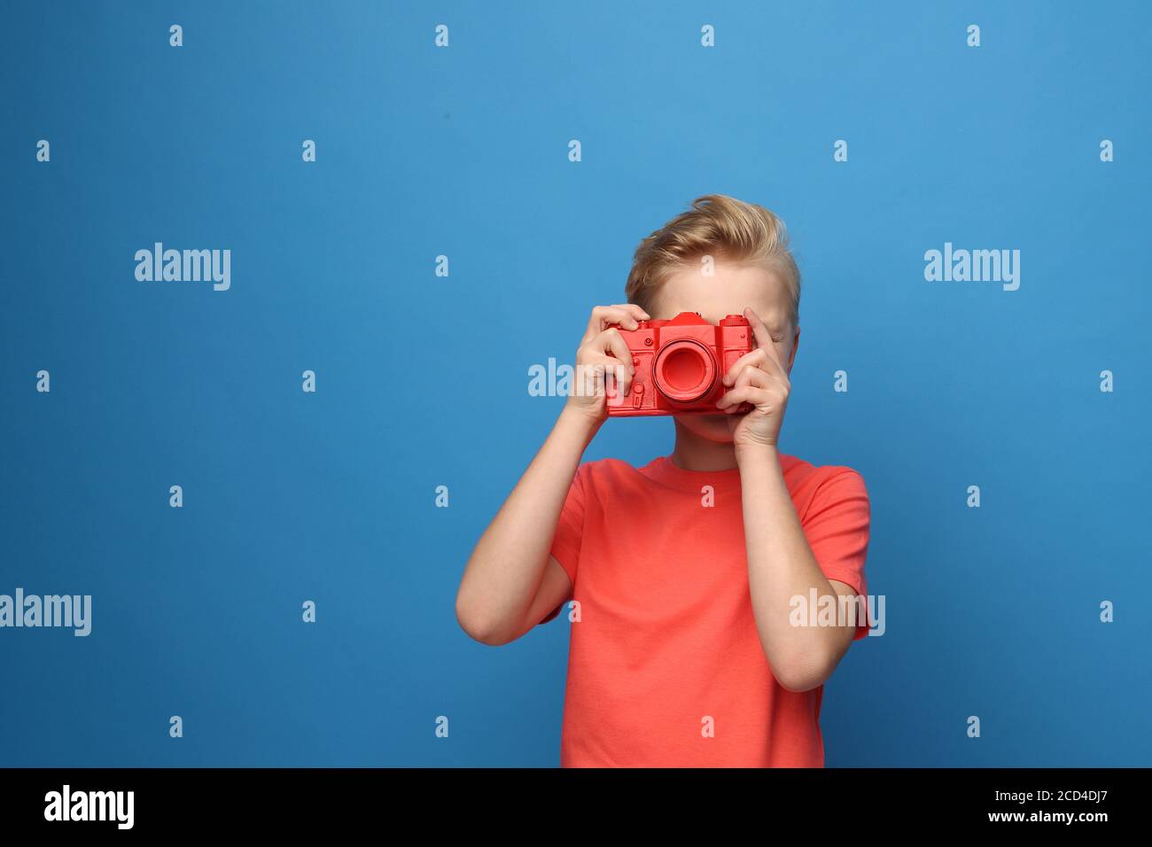 Photographer, child with a camera.   Portrait of a boy on a blue background. Stock Photo