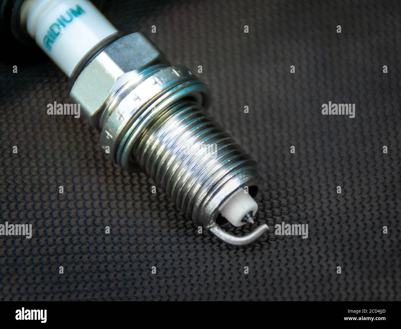 new iridium spark plug positioned diagonally against a dark background, selective focus Stock Photo