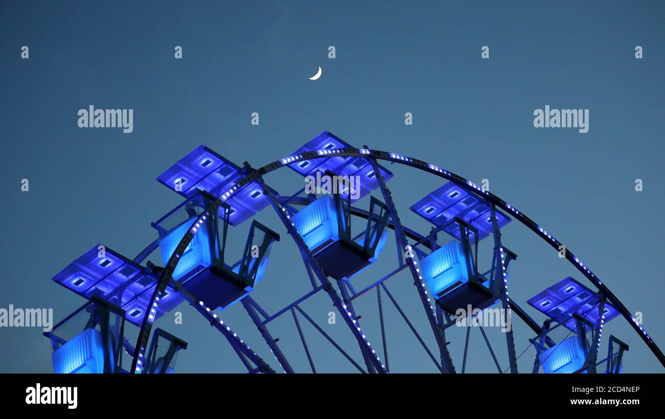 39/5000 Ferris wheel at sunset. With Moon. Stock Photo