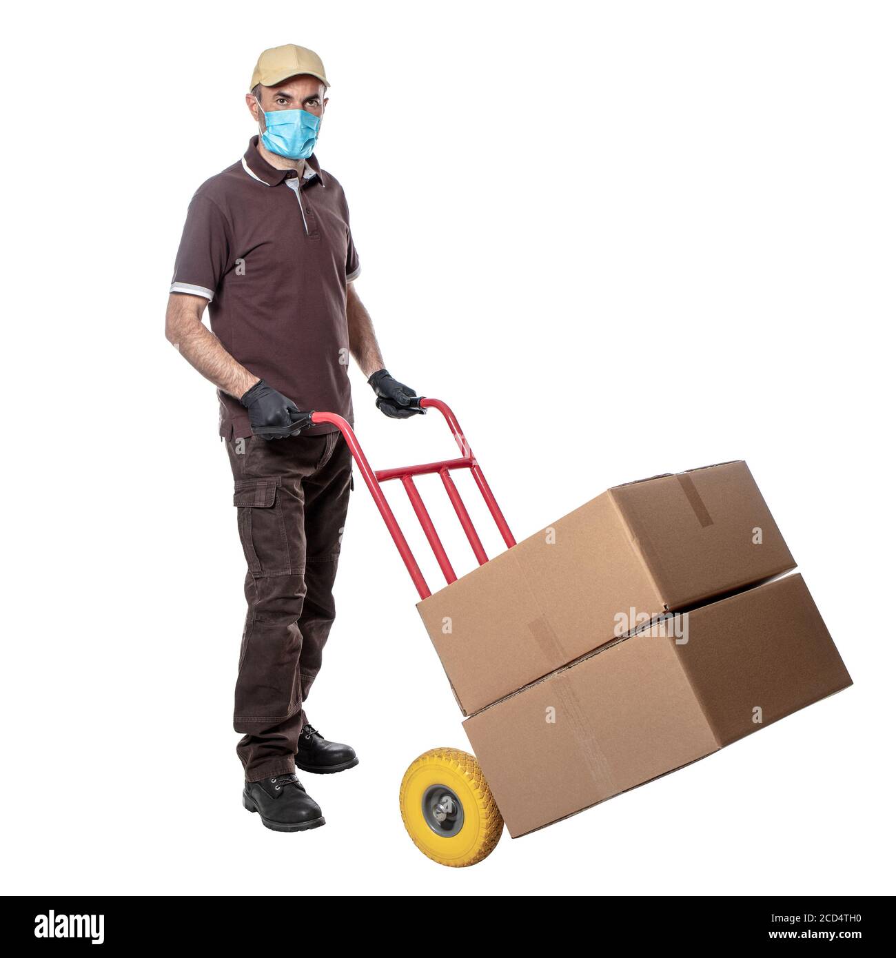delivery man with mask for covid-19. handtruck with packages. isolated on white. work safely. Stock Photo