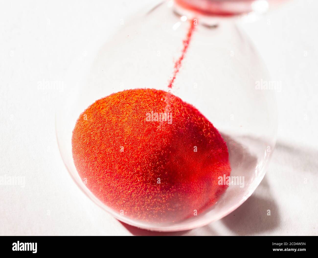 hourglass with red sand used to measure time flow, macro photography Stock Photo