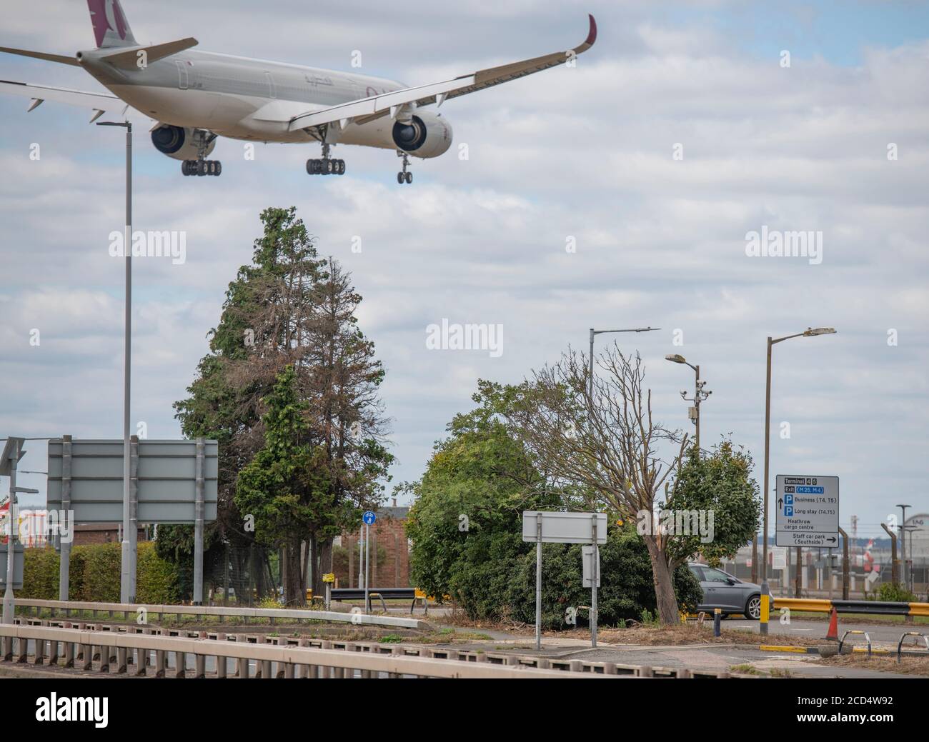 Heathrow Airport, London, UK. 26 August 2020. Qatar Airways Airbus A350 A7-ANK from Doha crosses the A30 Great South West Road before touching down on runway 27L at Heathrow. COVID-19 pandemic has seen the airline industry slump worldwide, with approx 11% of passengers at Heathrow in July 2020 compared with the same month in 2019, and approx 25% of air traffic movements at Heathrow in July 2020 compared with July 2019. Credit: Malcolm Park/Alamy. Stock Photo