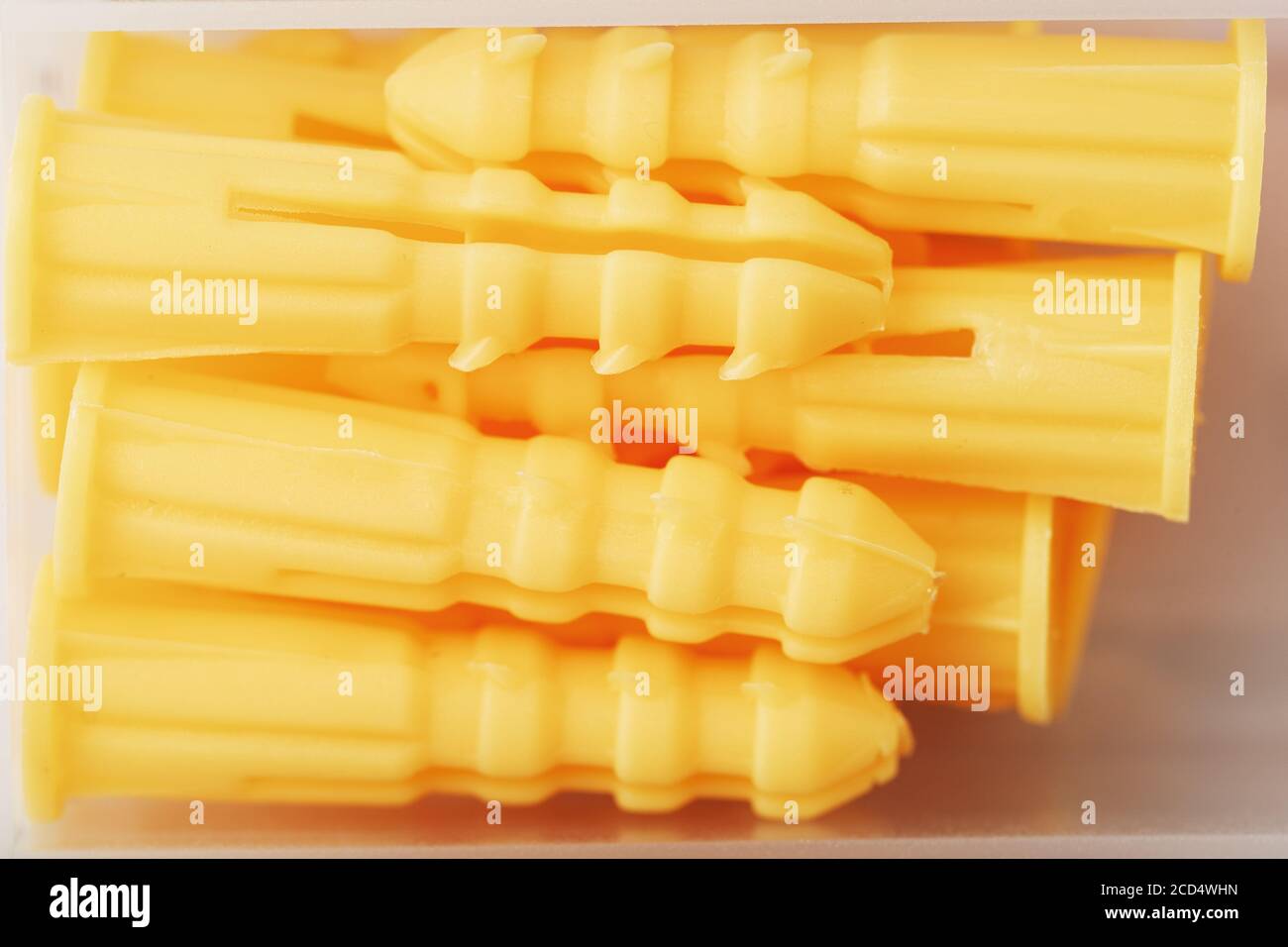 Yellow plastic dowels for self-tapping screws close-up. Stock Photo