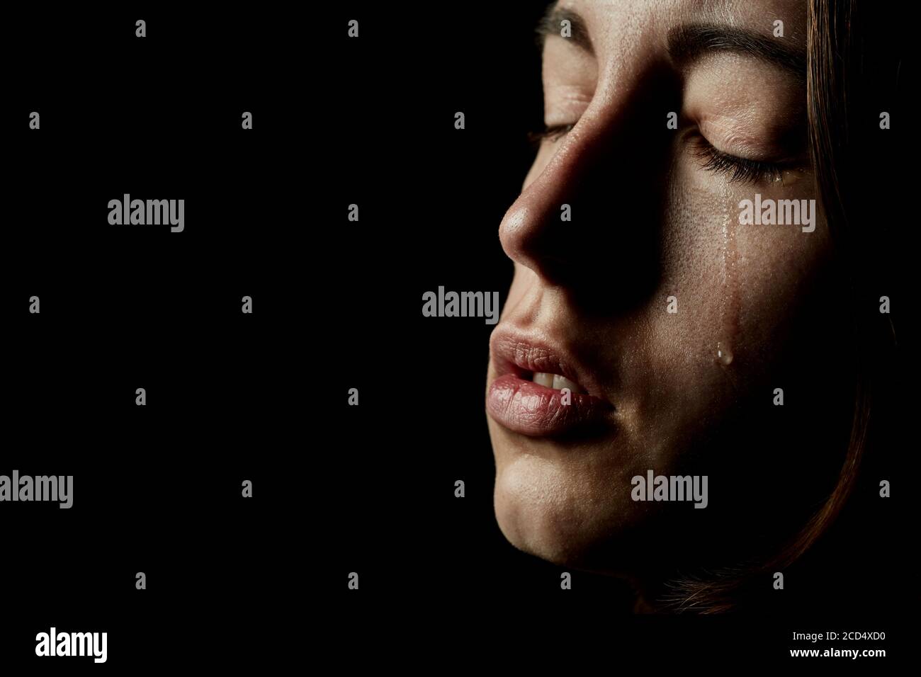 sad woman crying on black background, closeup portrait Stock Photo - Alamy
