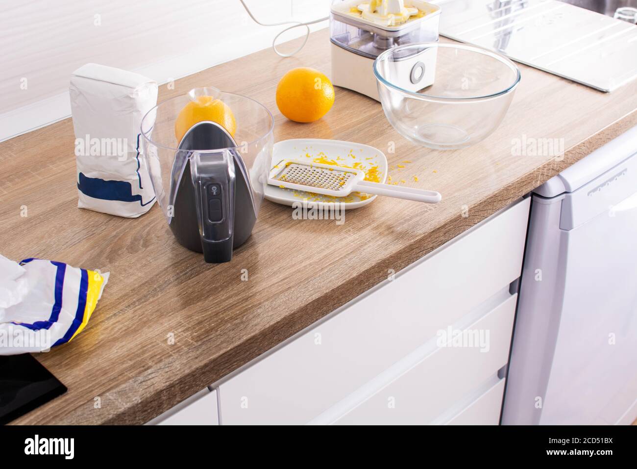 Rubbing orange zest in the kitchen Stock Photo