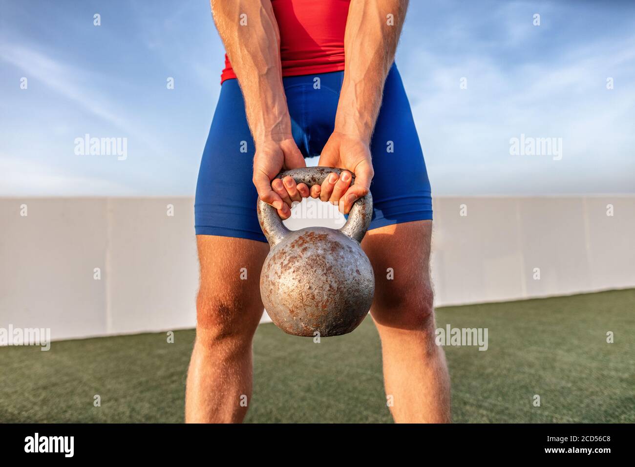 Kettlebell weightlifting fit man lifting crossfit weight at outdoor gym for squat leg workout Stock Photo