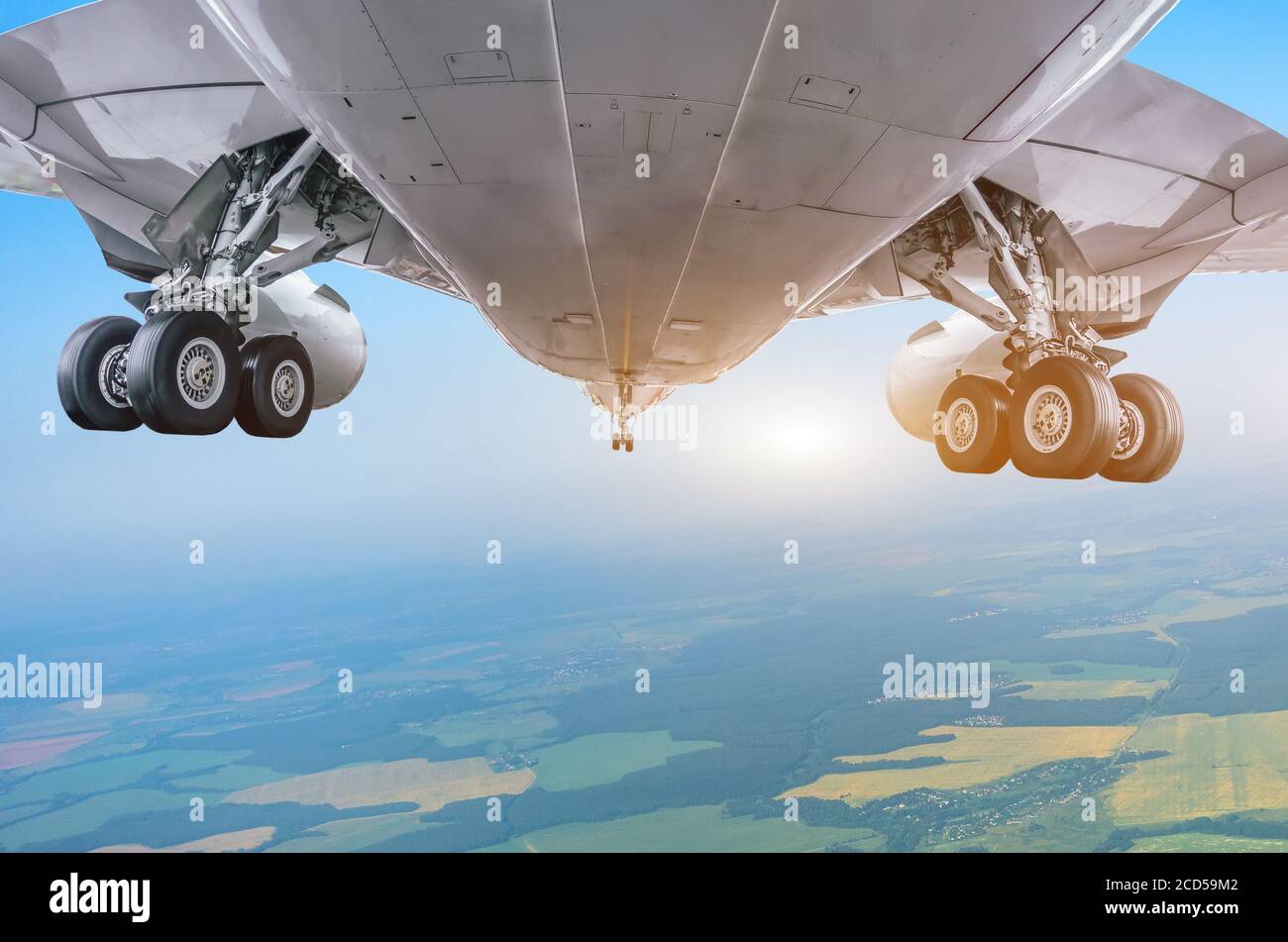 View from under the flying aircraft with the landing gear extended before approach at the airport Stock Photo