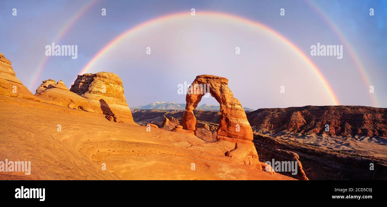 View of rainbow over canyon, Arches National Park, Utah, USA Stock Photo