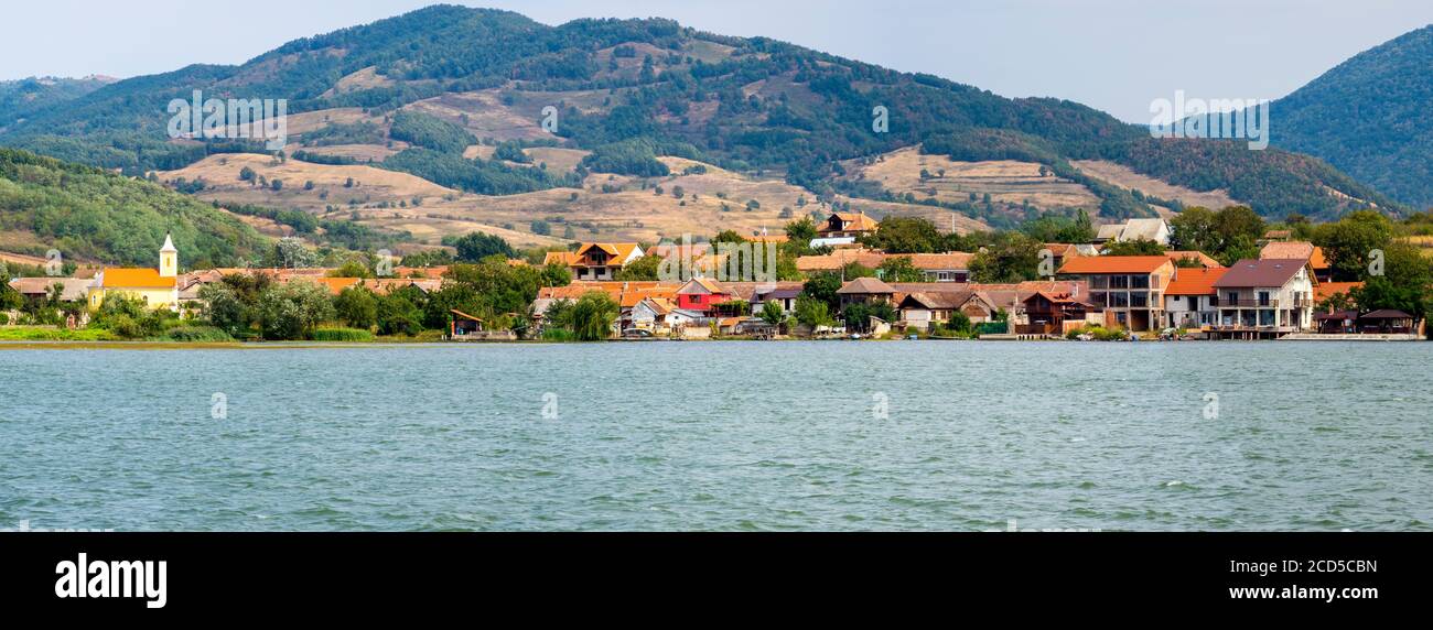 View of village near river, Romania Stock Photo