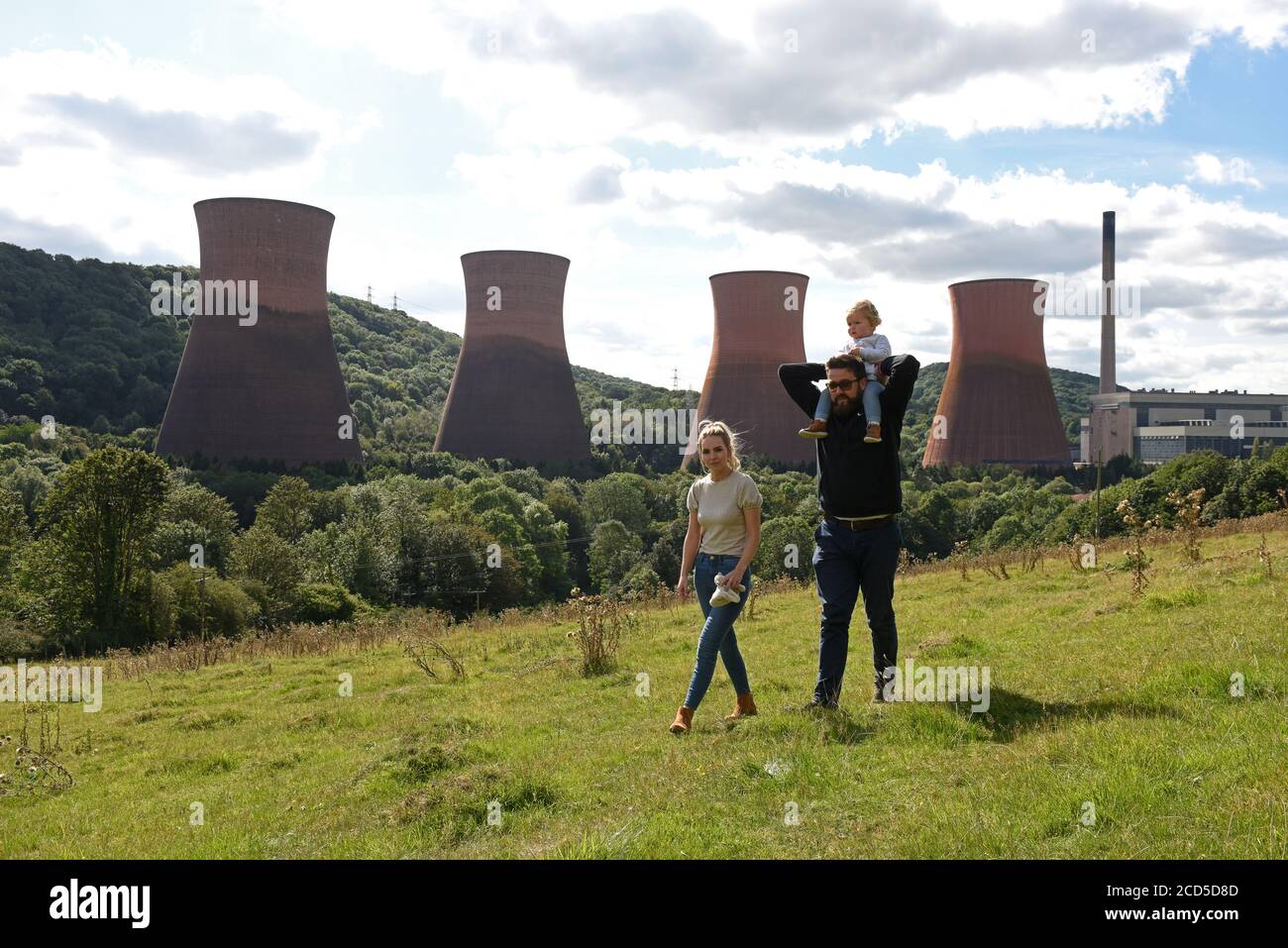 Family walking on  Strethill Meadow overlooking the cooling towers of Ironbridge Power Station. Stock Photo