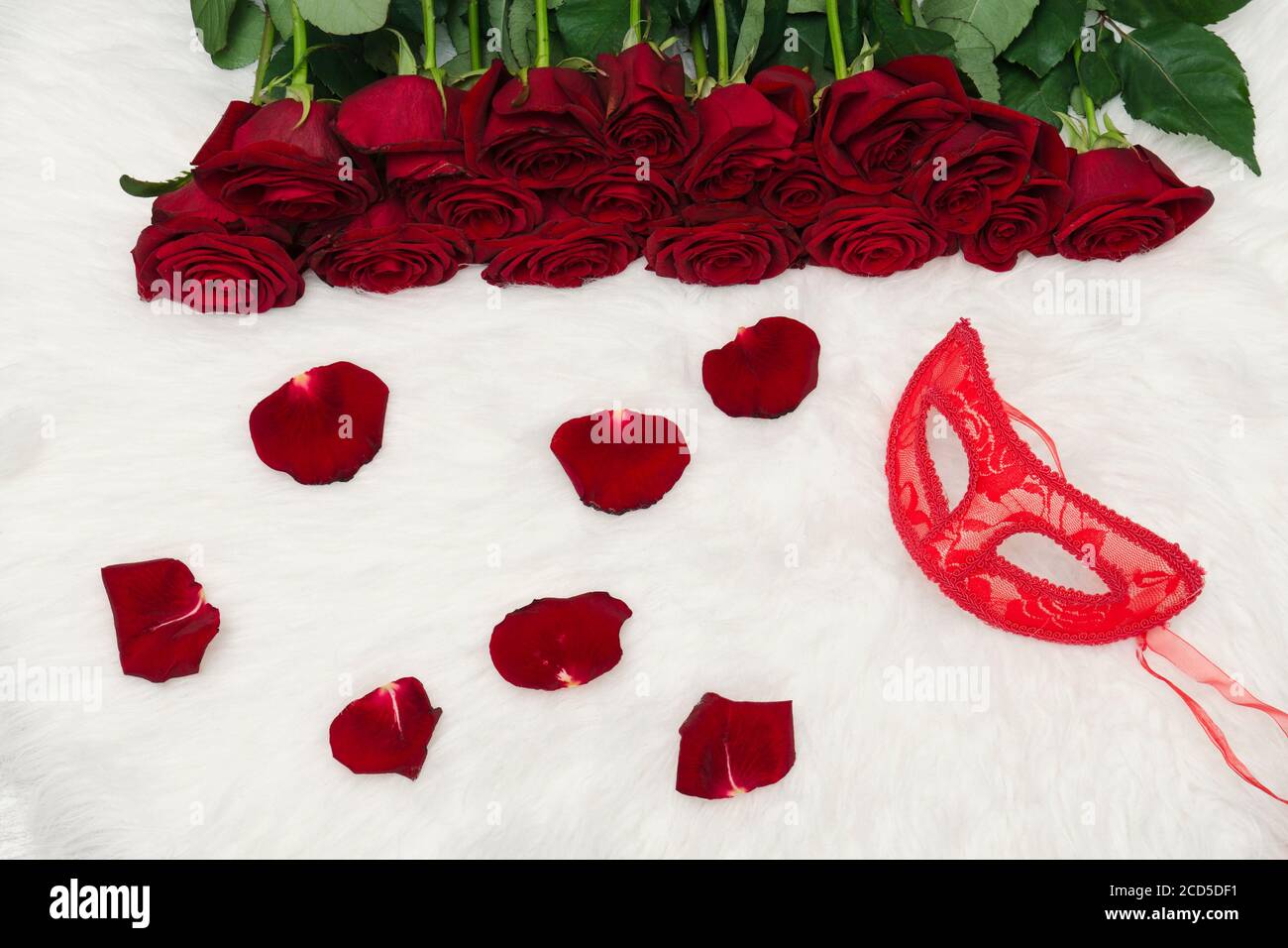 Romantic carnival concept. Red carnival mask, bouquet of red roses and ...