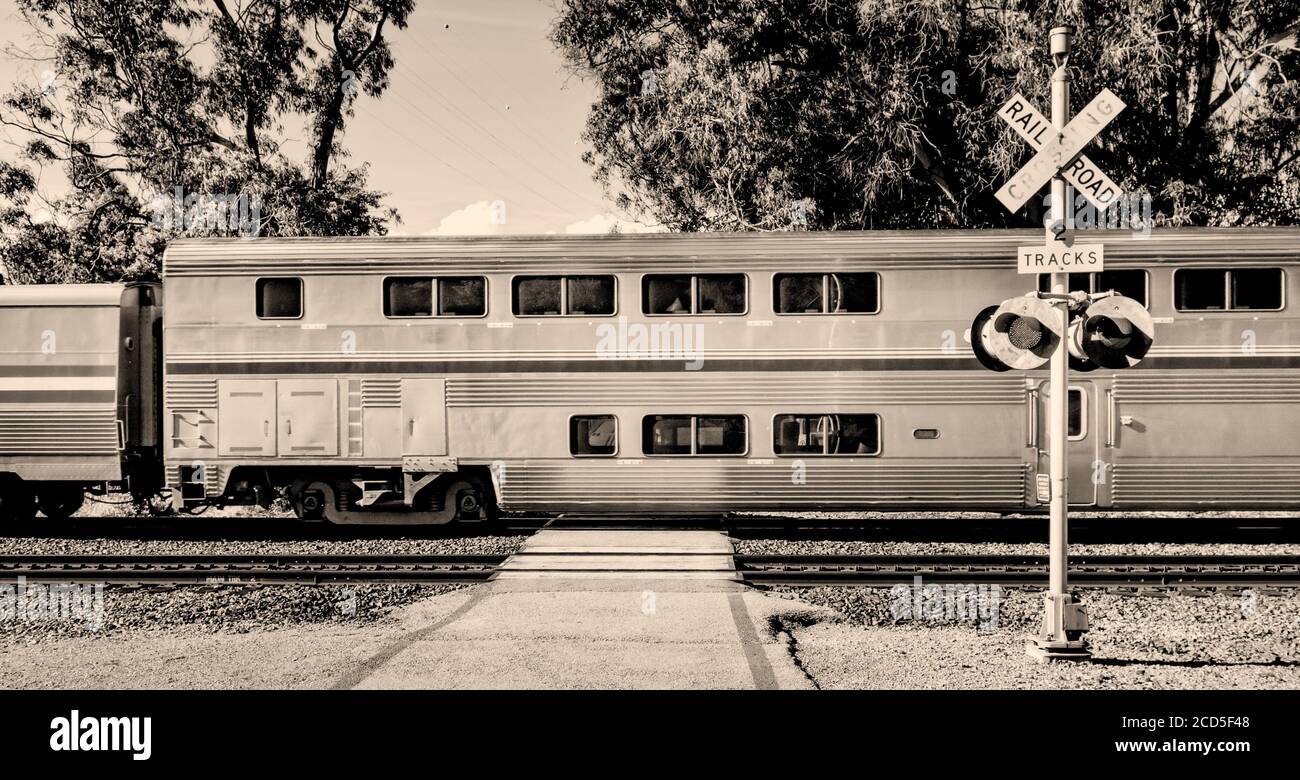 Black and white photograph of passenger train and railroad crossing, California, USA Stock Photo