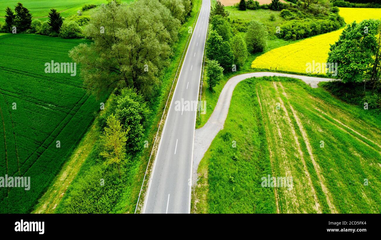 Aerial view of road between fields Stock Photo