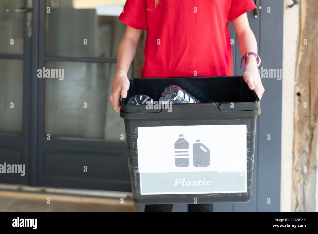 Child holding recycling bucket full of plastic bottles Stock Photo Alamy