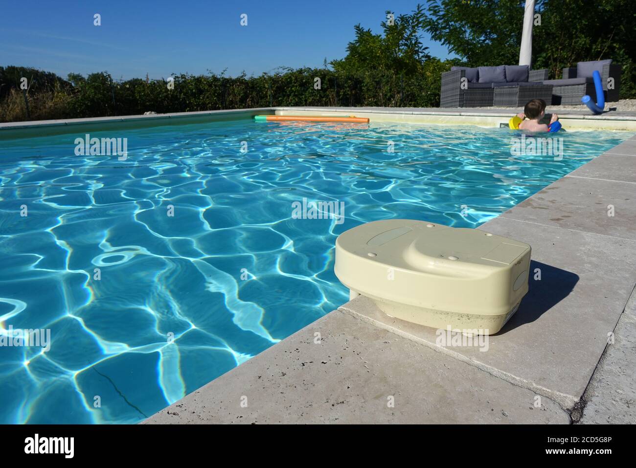 Swimming pool alarm on the side of an in ground pool with a child in