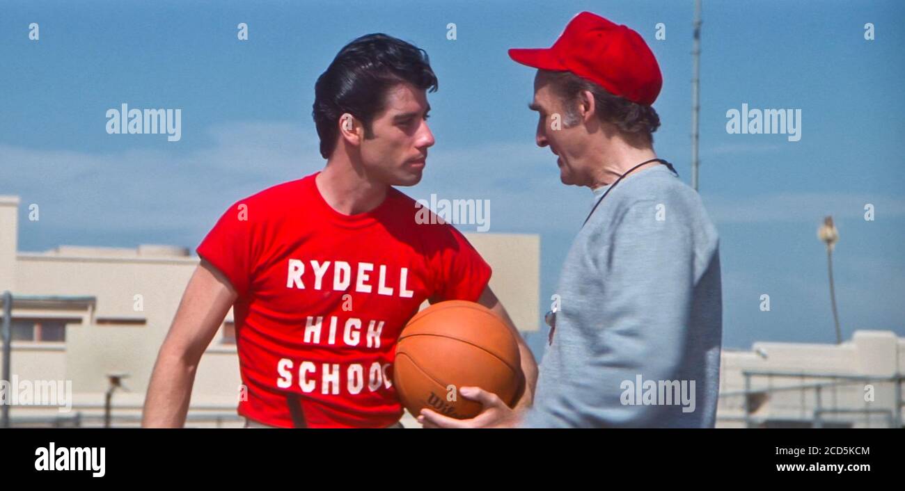 USA. John Travolta and Sid Caesar in a scene from the ©Paramount Pictures  movie: Grease (1978). Plot: Good girl Sandy Olsson and greaser Danny Zuko  fell in love over the summer. When