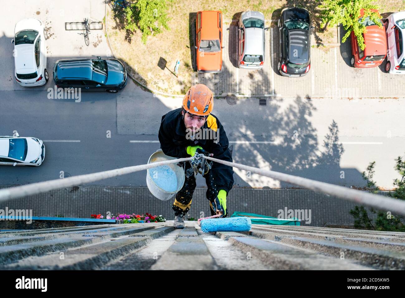 Male worker hanging on rope access and height construction project