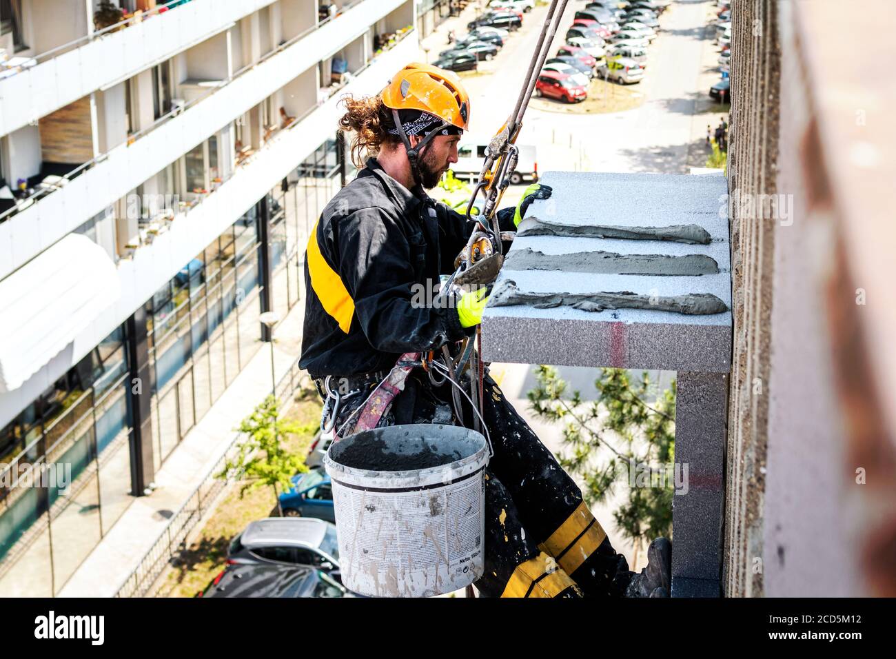 Male worker hanging on rope access and height construction project