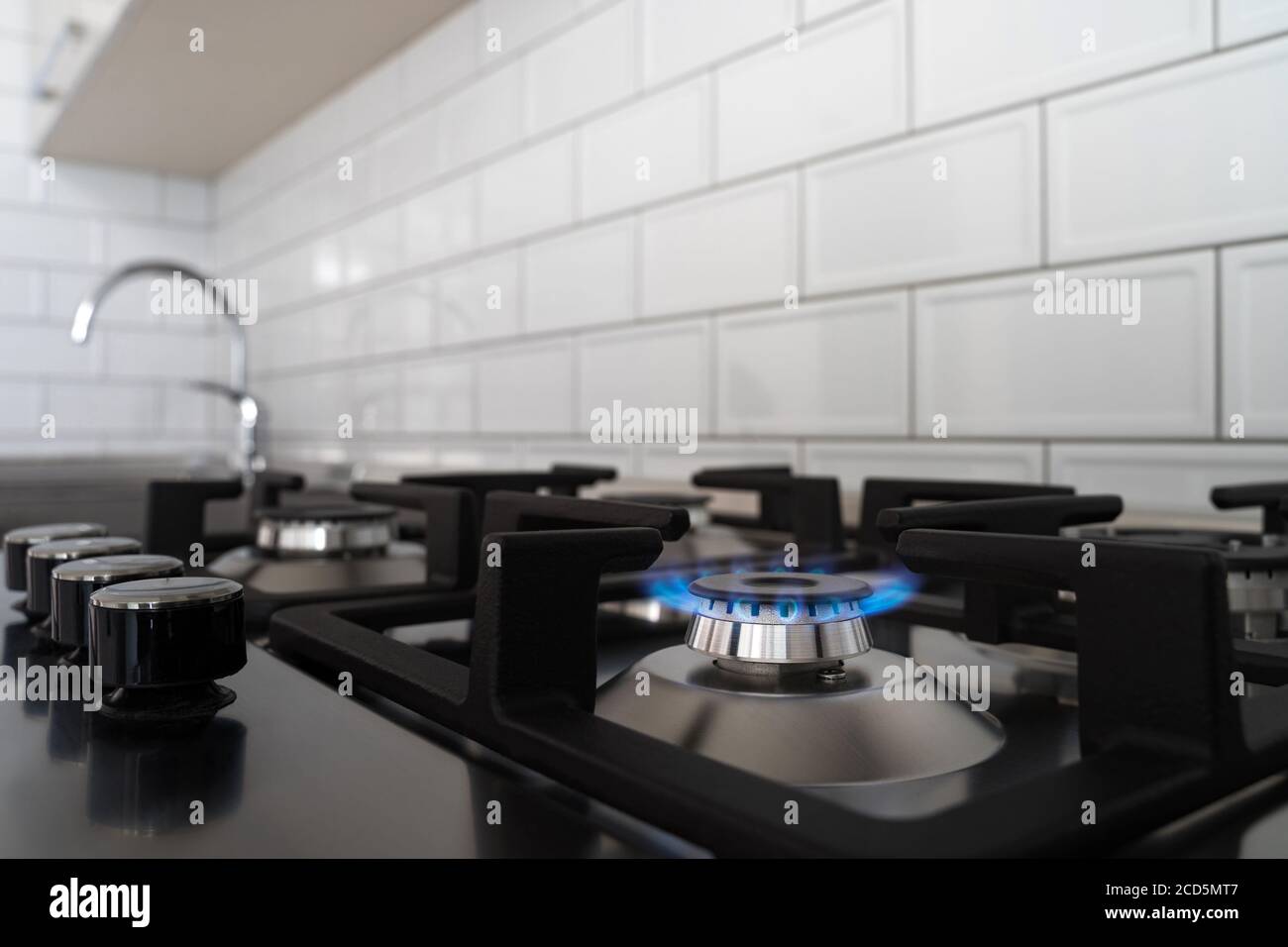 Blue flame from a gas stove burner. Stainless steel kitchen
