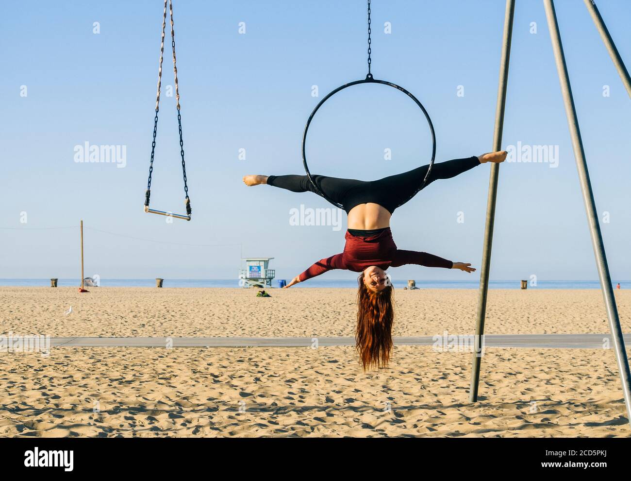 Female aerialist acrobat on beach near Santa Monica Pier, Santa Monica, California, USA Stock Photo