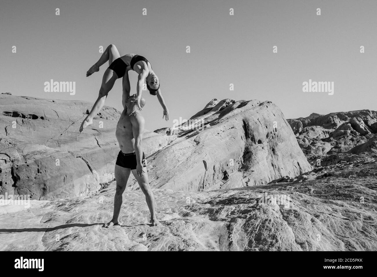 Balancing pair of gymnasts in desert,  State Park, Overton, Nevada, USA Stock Photo