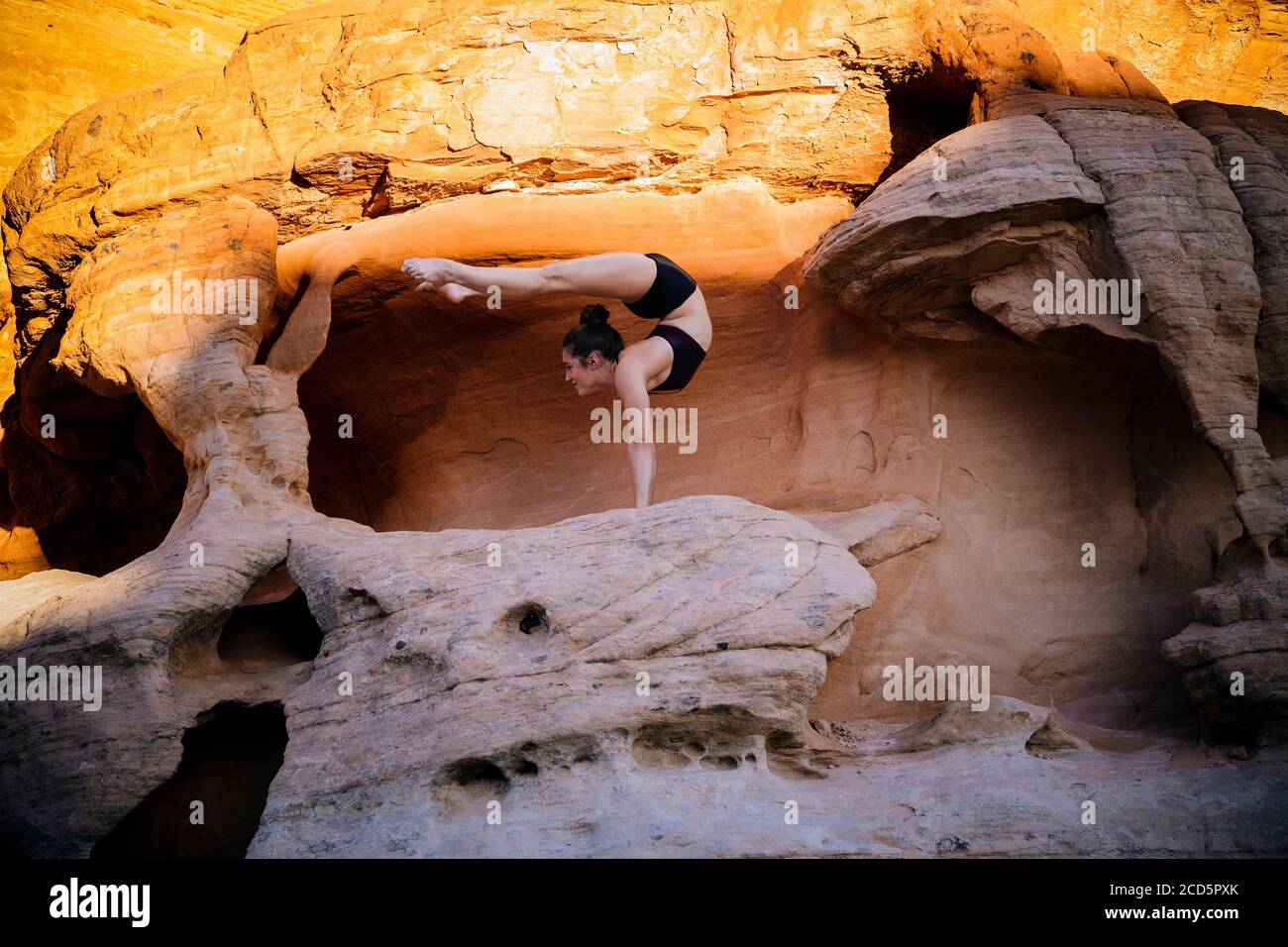 Female gymnast doing handstand in desert,  State Park, Overton, Nevada, USA Stock Photo