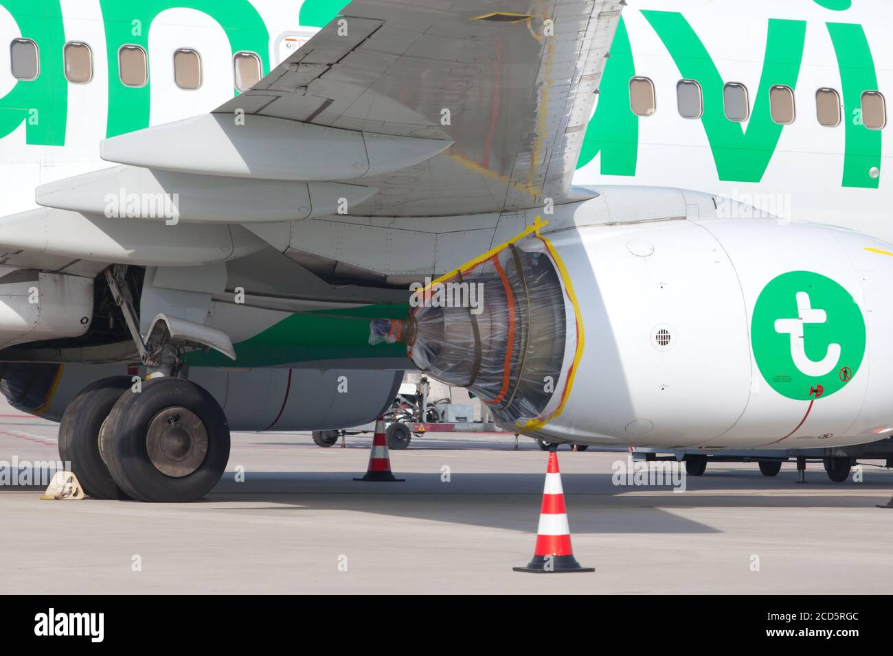 ROTTERDAM - A transavia airplane stands idle at the runway with a wrapped up motor due to the corona travel ban Stock Photo