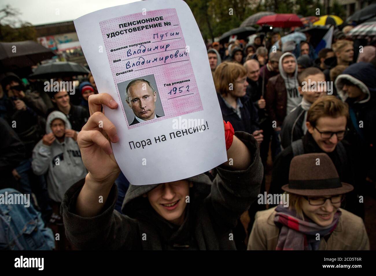 Moscow, Russia. 7th October, 2017. People attend an unauthorized anti-Kremlin rally called by opposition leader Alexei Navalny, who is serving a 20-day jail sentence, in downtown Moscow at day of President Vladimir Putin's 65th birthday. A young man holds a pension certificate with portrait Vladimir Putin with inscription 'It's time to retire' Stock Photo