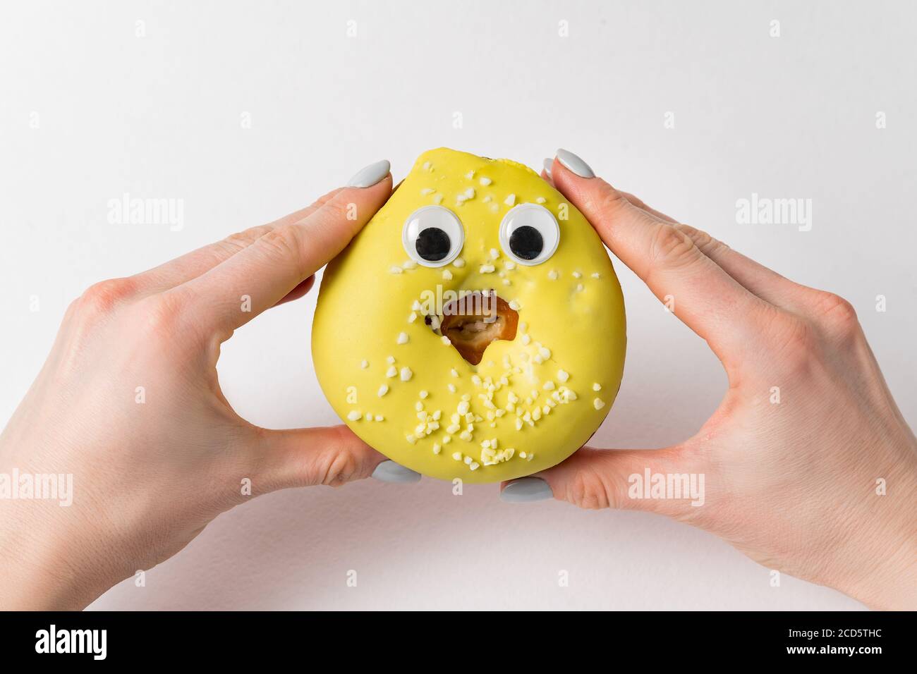 Two hands holding funny donut with huge eyes on white background. doughnut  with face Stock Photo - Alamy