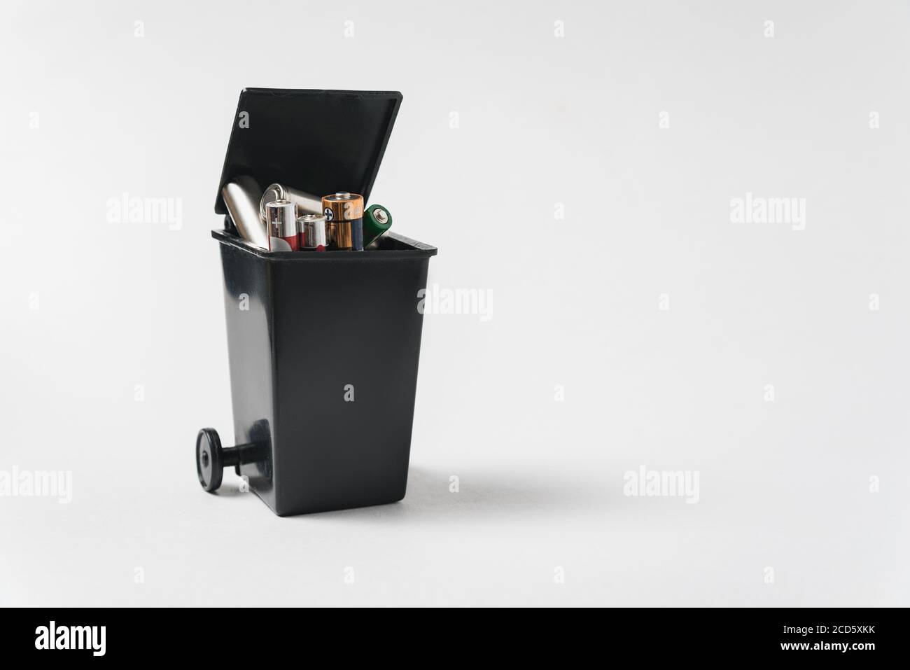 Used batteries in the bin on a white background. Electronic waste