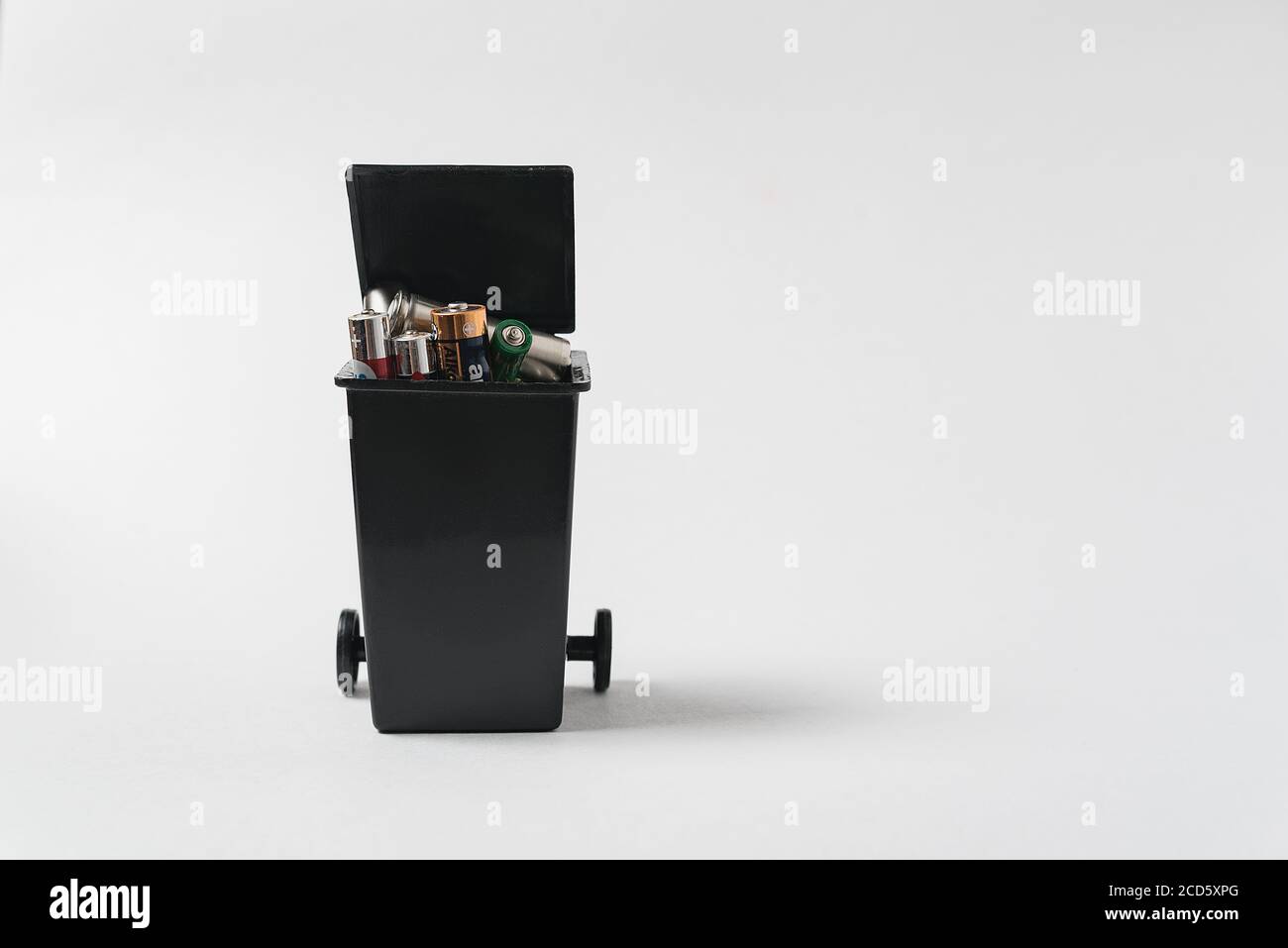 Used batteries in the garbage container on white background