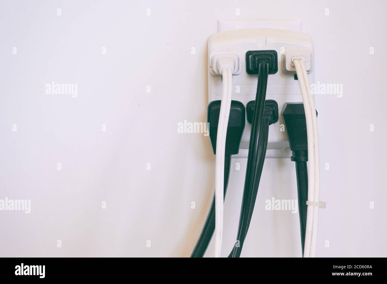 Electrical cables plugged into wall outlet Stock Photo Alamy