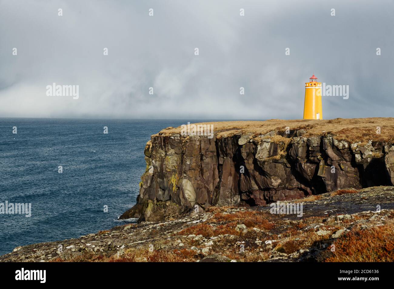 Gerdistangi Lighthouse on seashore under overcast sky, Keflavik, Iceland Stock Photo