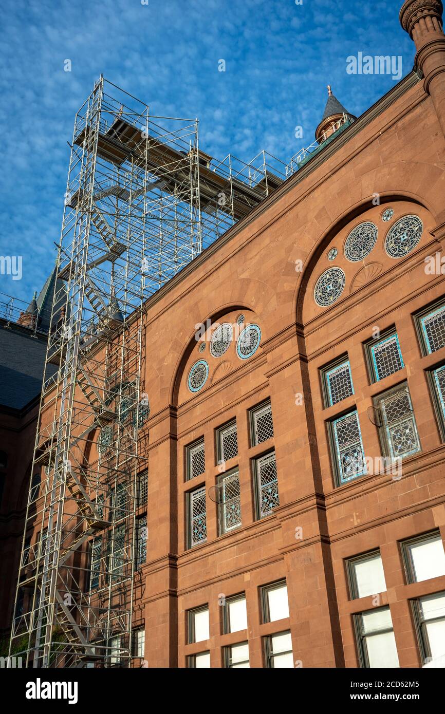 Scaffolding rises over the stained glass windows of Crouse College