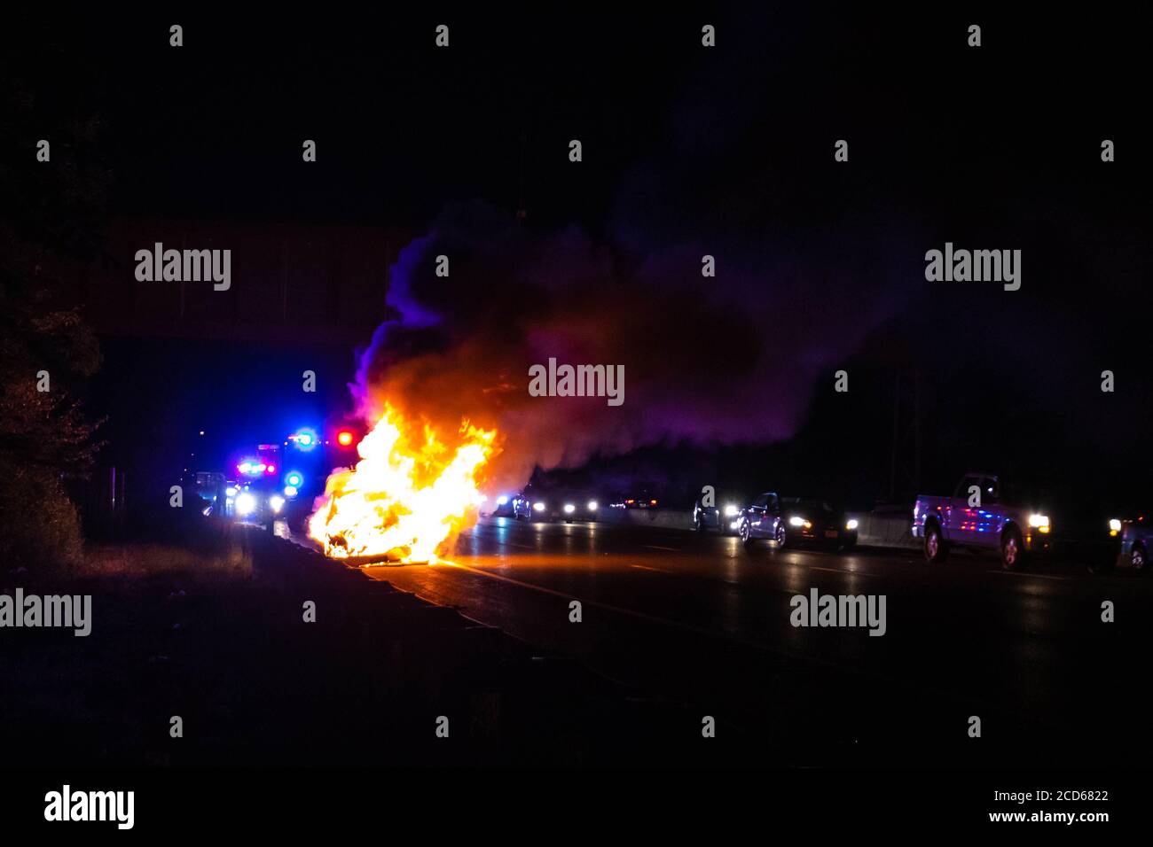Car on fire night accident on the highway road with police Stock Photo