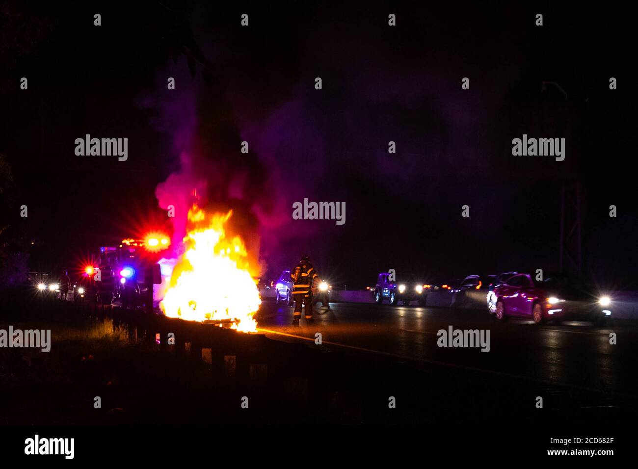 Car on fire night accident on the highway road with police Stock Photo