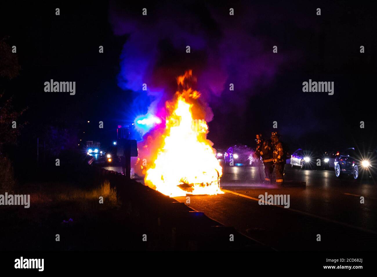 Car on fire night accident on the highway road with police Stock Photo