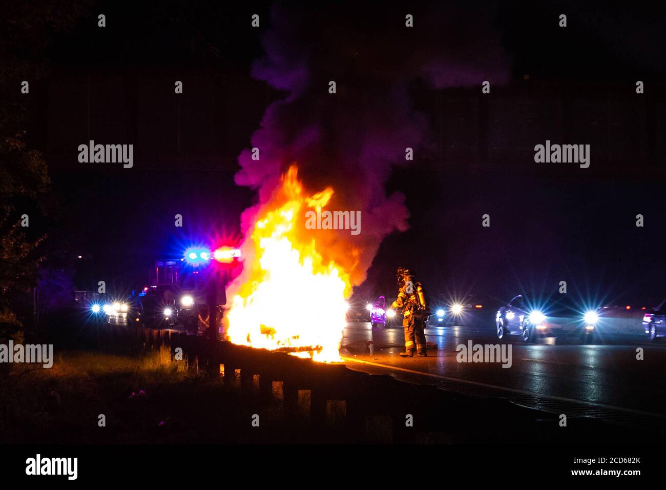 Car on fire night accident on the highway road with police Stock Photo