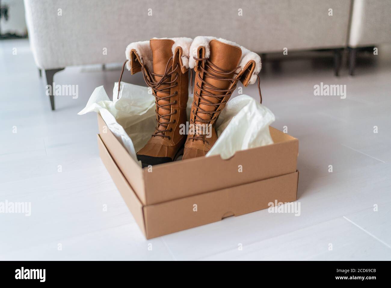 New winter boots buying new hiking shoes online shopping and delivery.  Opening shoe box in living room at home Stock Photo - Alamy