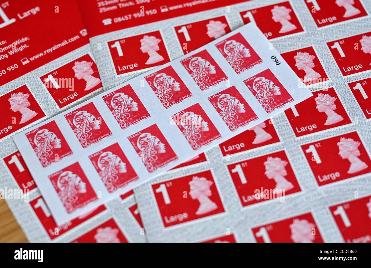 20 August 2020, Saxony, Schkeuditz: Counterfeit stamps of the British and French postal services are on a table in the customs office at Leipzig Airport. For the shoes, counterfeiters sewed a patch over the Nike logo for transport, which was to be removed later at the destination. The items seized range from mobile phone cases with the vehicle logo to luxury watches. In 2019, almost 5.2 million goods were removed from circulation. The manufacturers of the originals were thus spared damages of around 224 million euros. Compared to 2017, there was a sharp increase in cases in the two following y Stock Photo