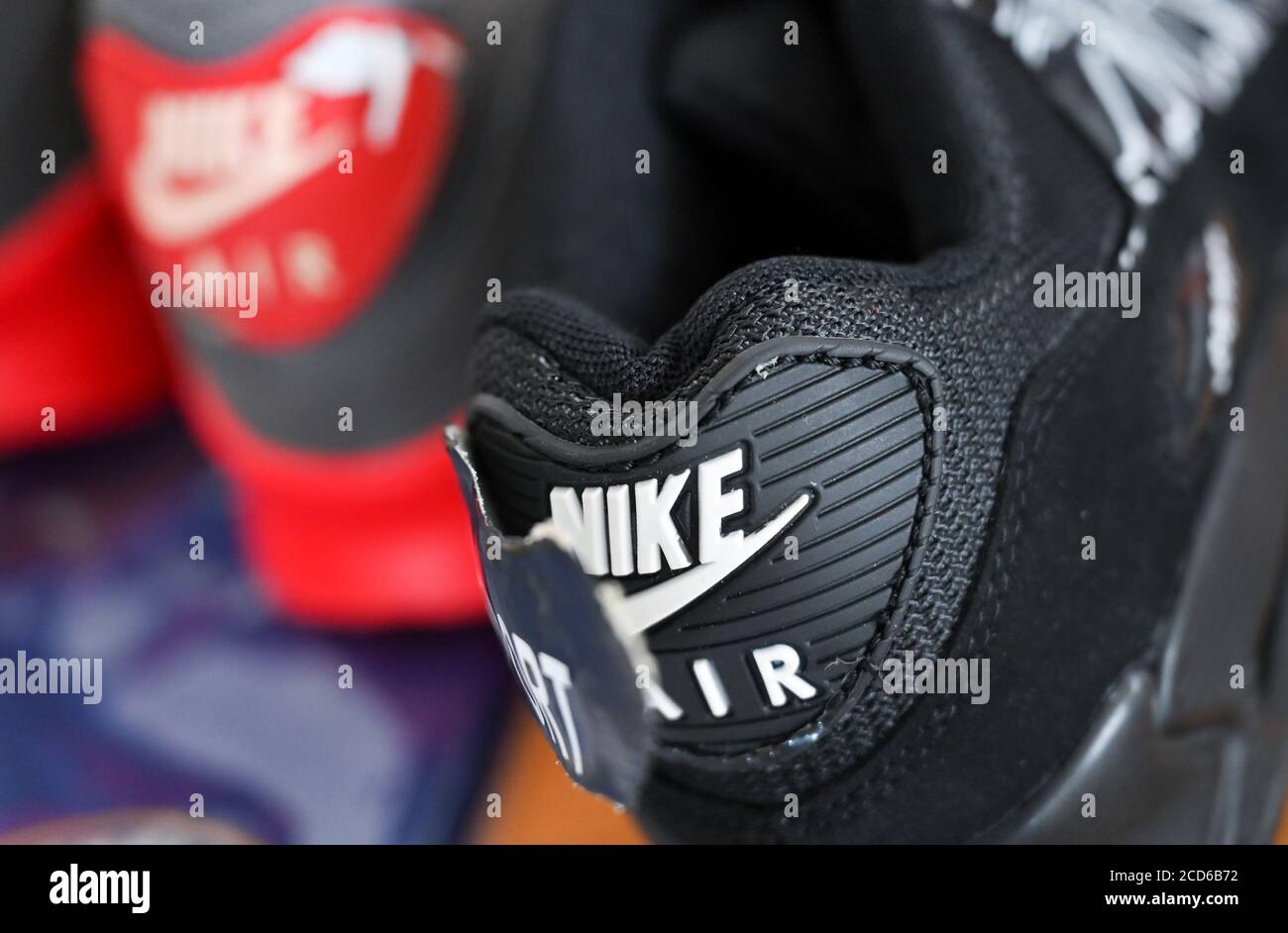 20 August 2020, Saxony, Schkeuditz: Counterfeit sports shoes from Nike can  be found on a table in the customs office at Leipzig Airport.  Counterfeiters sewed a patch over the Nike logo on