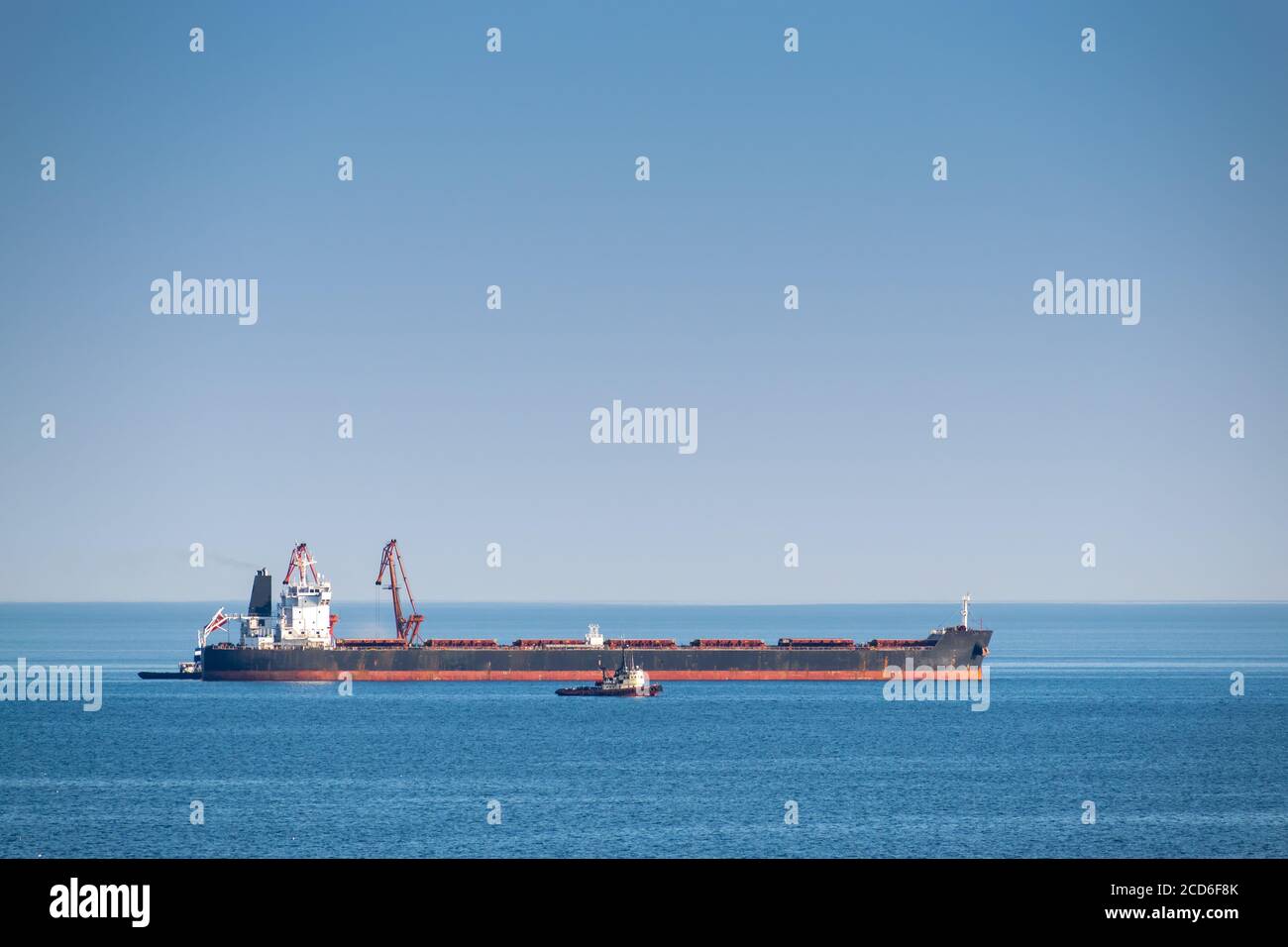 Bulk carrier ship is being loaded at sea Stock Photo