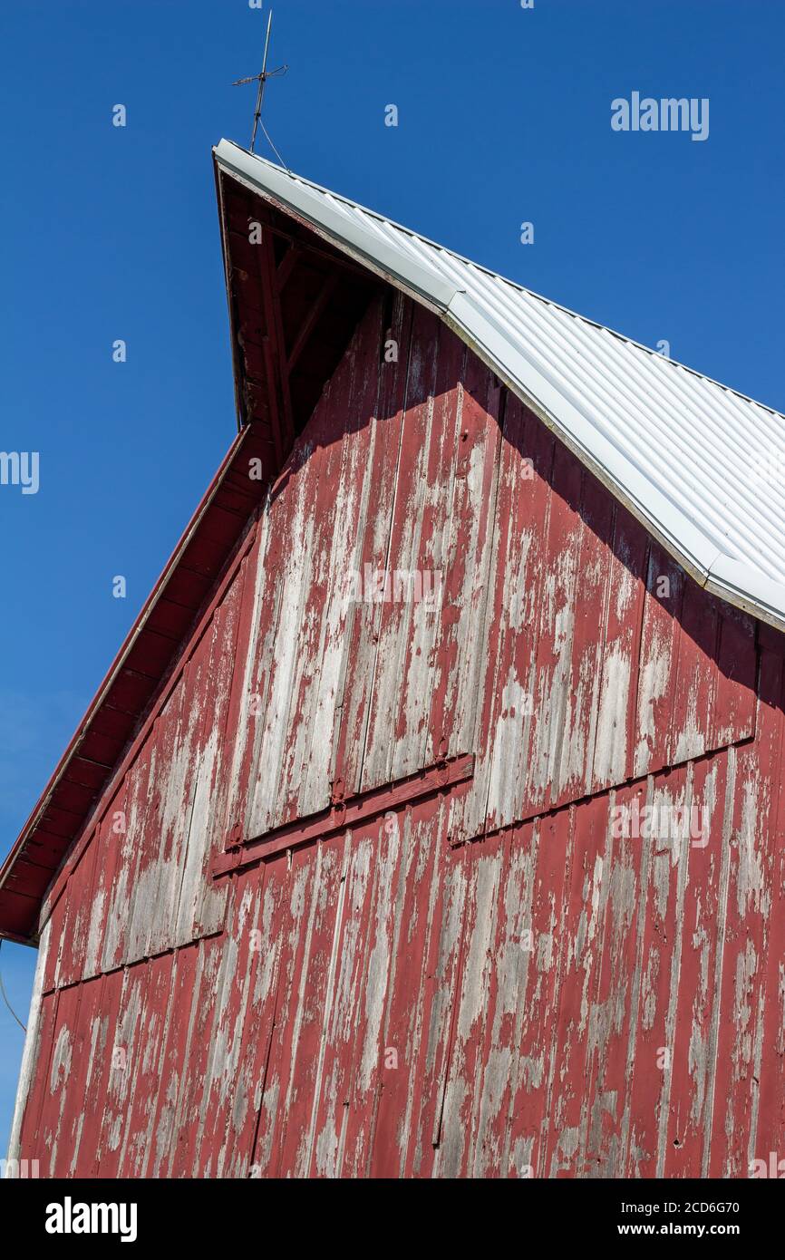 Close upward view of a hayloft door on a rustic late 19th Century wooden barn with blue sky and copy space Stock Photo
